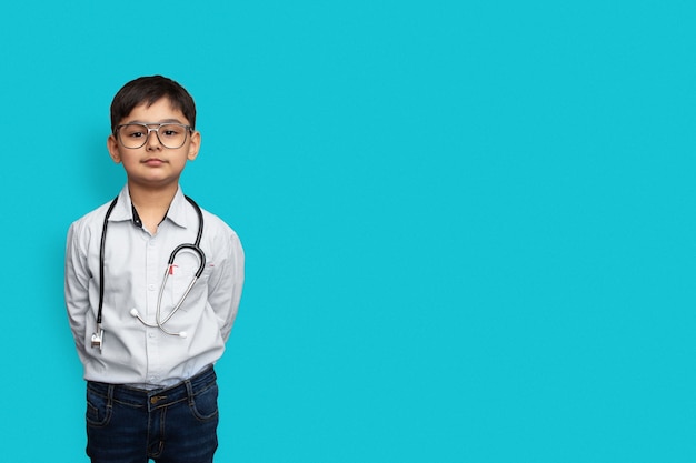 Smiling little boy with stethoscope and glasses isolated background with copy space