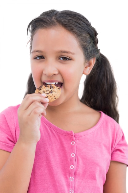 Smiling little girl eating a cookie