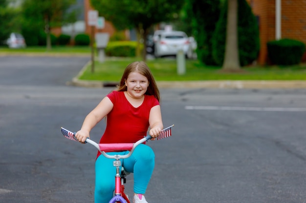 街の公園で自転車に乗って夏服の少女の笑顔