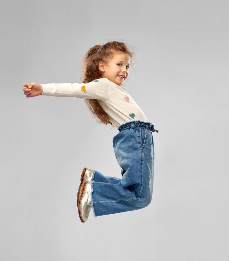 Photo 笑顔の小さな女の子がジャンプする