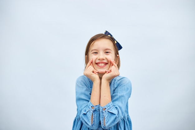 Smiling little girl make trend mini heart sign with fingers