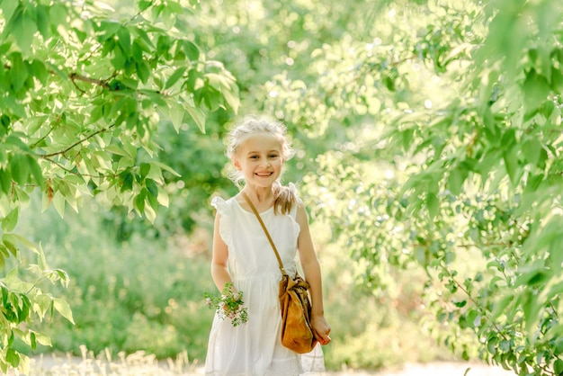 Smiling little girl in the park with flower