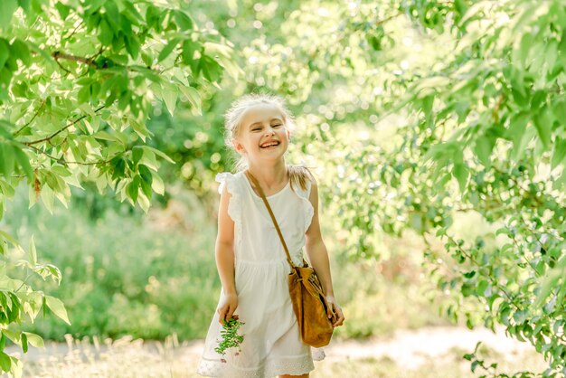 Smiling little girl in the park with flower