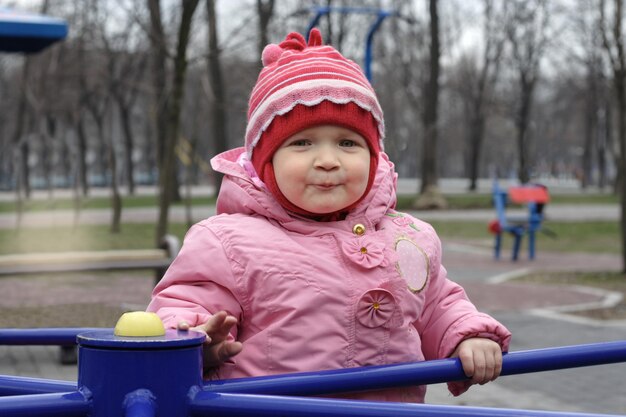 Улыбающаяся маленькая девочка на детской площадке
