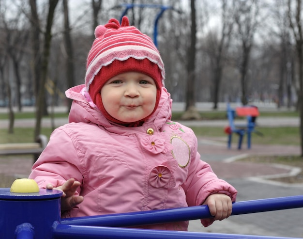 Улыбающаяся маленькая девочка на детской площадке