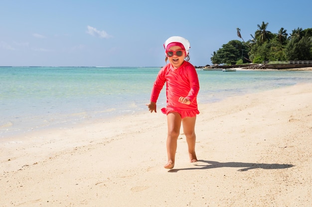 Smiling Little Girl Running On The Beach