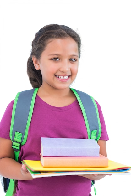 Smiling little girl wearing book bag and holding her homework