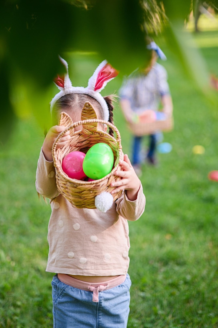 Photo smiling little girl with bunny ears and easter basket outdoors