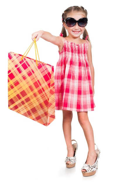 Улыбающаяся маленькая девочка с сумкой для покупок