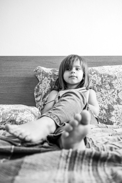 Smiling little girl writing on a paper notebook at home on bed Little girl thinking about her dreams or looking for an idea Copy space for text Black and White