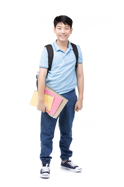 Smiling little student boy in blue polo t-shirt in with books and bag.