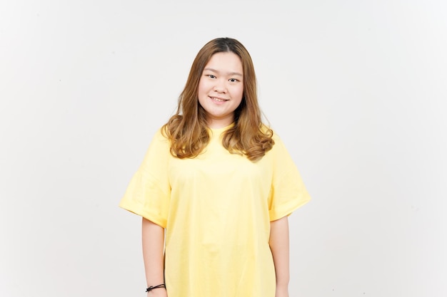 흰색으로 격리된 노란색 티셔츠를 입은 아름다운 아시아 여성의 카메라를 보고 웃고