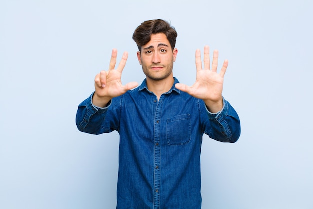 smiling and looking friendly, showing number eight or eighth with hand forward, counting down