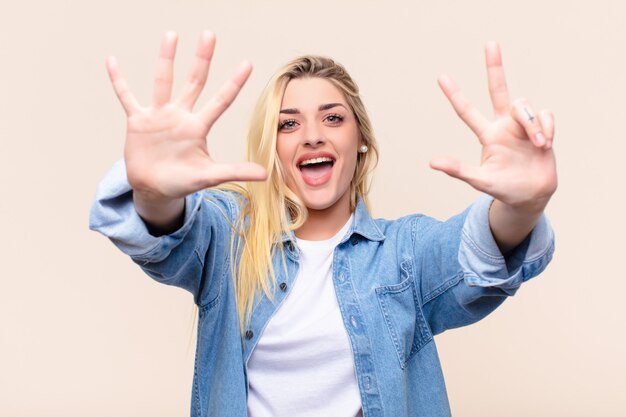 smiling and looking friendly, showing number eight or eighth with hand forward, counting down