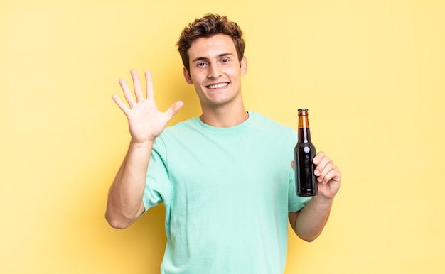 Smiling and looking friendly, showing number five or fifth with hand forward, counting down. beer bottle concept