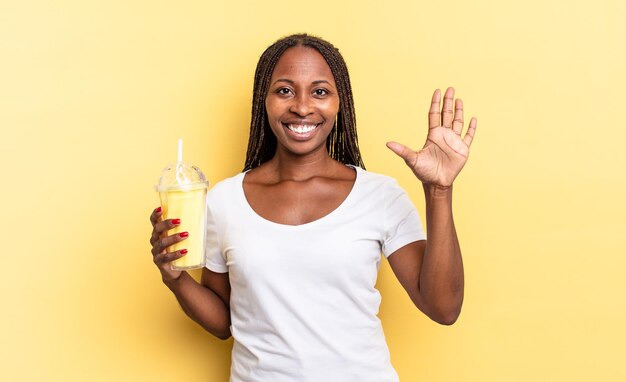 Smiling and looking friendly, showing number five or fifth with hand forward, counting down. milkshake concept