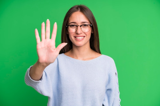 Smiling and looking friendly showing number five or fifth with hand forward counting down