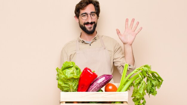 smiling and looking friendly, showing number five or fifth with hand forward, counting down