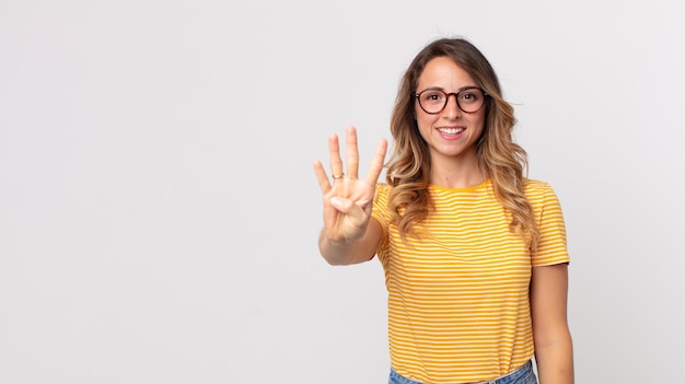 Smiling and looking friendly showing number four or fourth with hand forward counting down