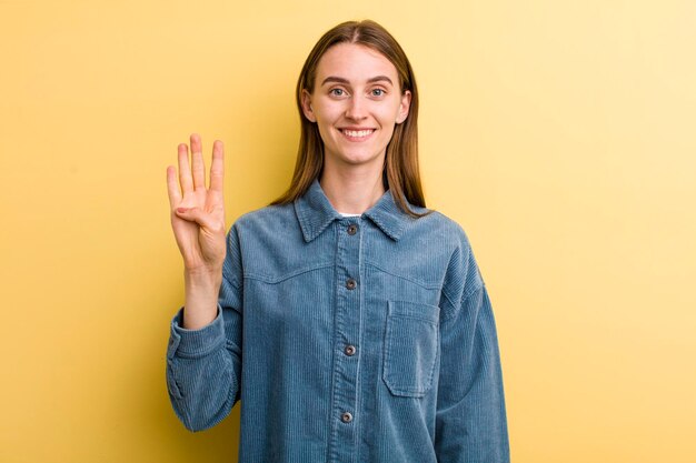 Smiling and looking friendly showing number four or fourth with hand forward counting down