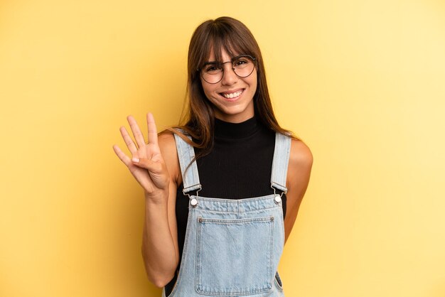 Smiling and looking friendly showing number four or fourth with hand forward counting down