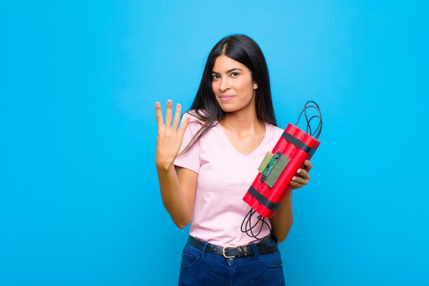 smiling and looking friendly, showing number four or fourth with hand forward, counting down