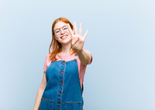 smiling and looking friendly, showing number four or fourth with hand forward, counting down