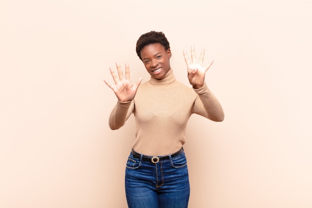 smiling and looking friendly, showing number nine or ninth with hand forward, counting down