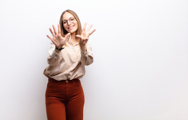 smiling and looking friendly, showing number nine or ninth with hand forward, counting down