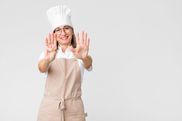 smiling and looking friendly, showing number nine or ninth with hand forward, counting down