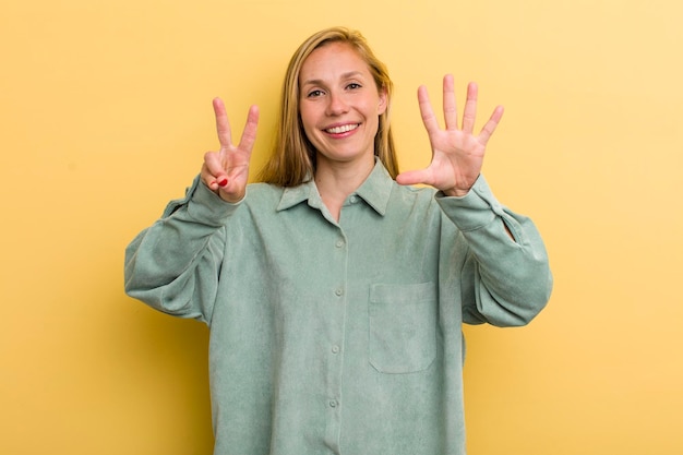 Foto sorridere e sembrare amichevole mostrando il numero sette o settimo con il conto alla rovescia in avanti della mano