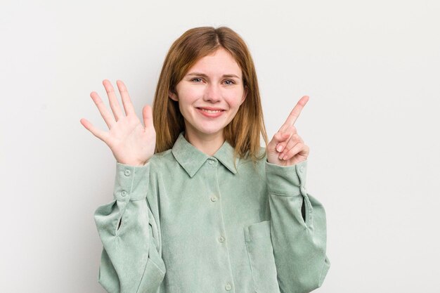 Smiling and looking friendly showing number six or sixth with hand forward counting down