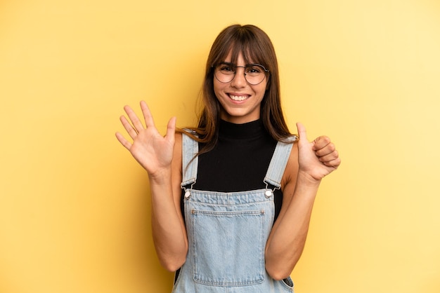 Smiling and looking friendly showing number six or sixth with hand forward counting down