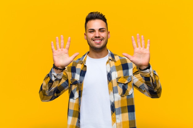 smiling and looking friendly, showing number ten or tenth with hand forward, counting down