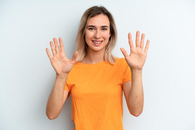 Smiling and looking friendly showing number ten or tenth with hand forward counting down