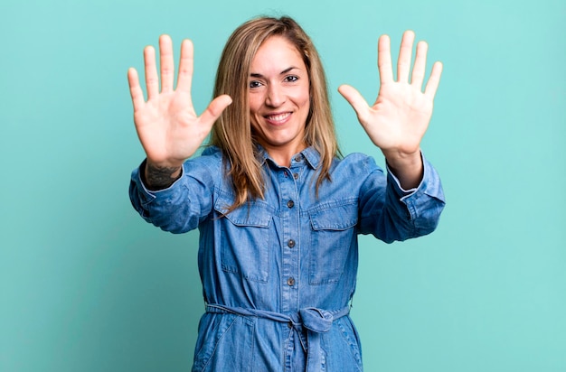 Smiling and looking friendly showing number ten or tenth with hand forward counting down