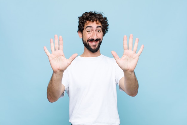 smiling and looking friendly, showing number ten or tenth with hand forward, counting down