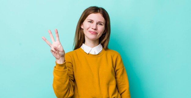 Smiling and looking friendly showing number three or third with hand forward counting down