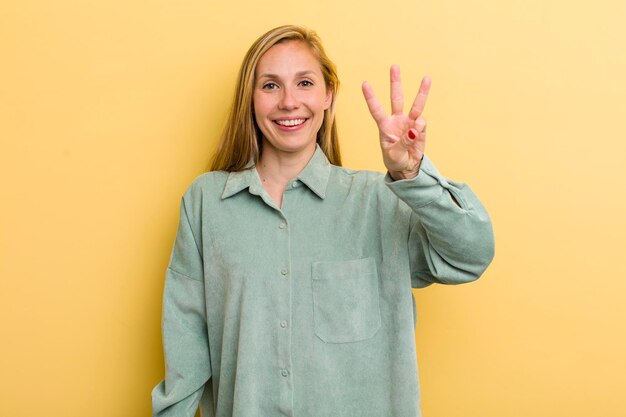 Smiling and looking friendly showing number three or third with hand forward counting down