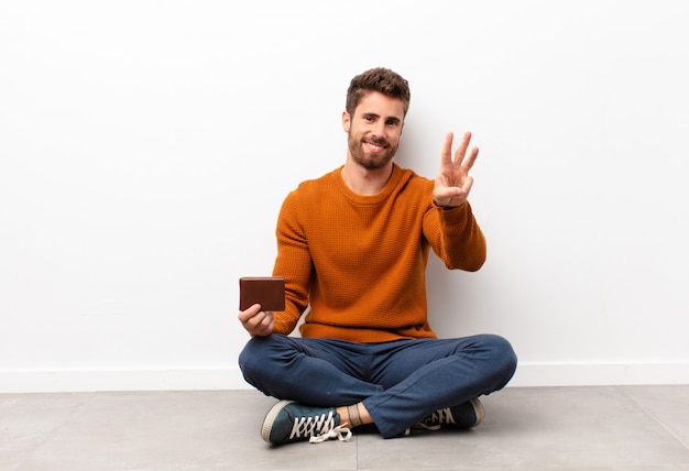 smiling and looking friendly, showing number three or third with hand forward, counting down