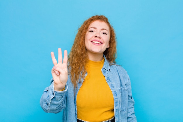 smiling and looking friendly, showing number three or third with hand forward, counting down