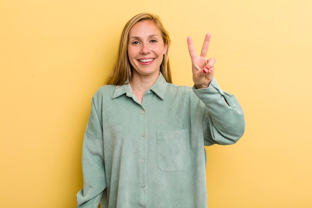 Smiling and looking friendly showing number two or second with hand forward counting down