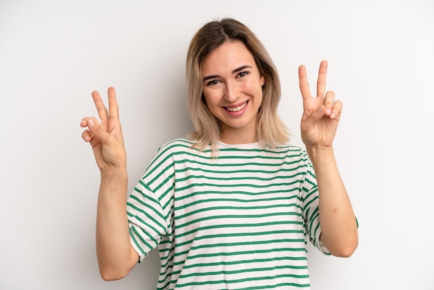 Smiling and looking happy friendly and satisfied gesturing victory or peace with both hands