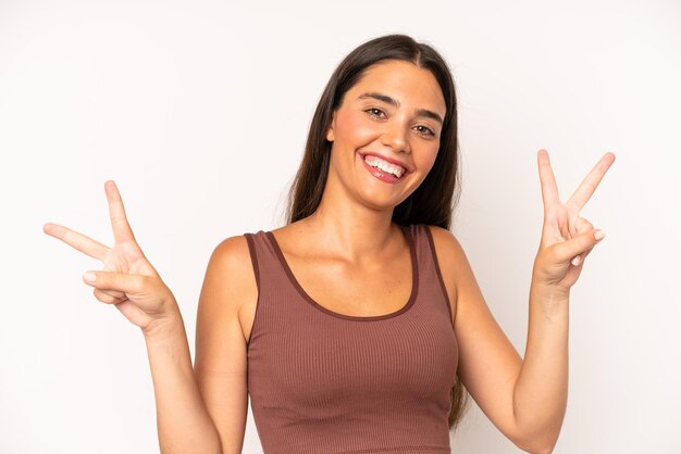 Smiling and looking happy friendly and satisfied gesturing victory or peace with both hands