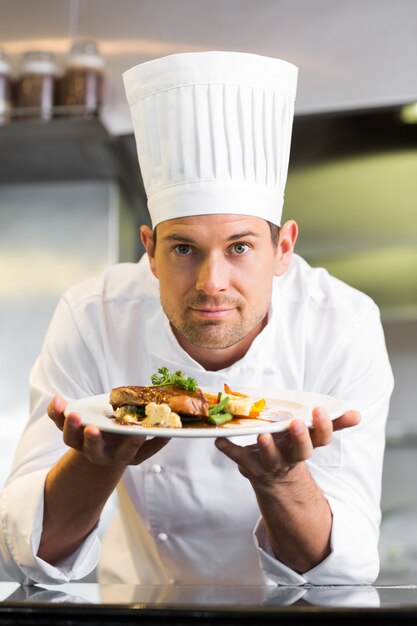 Smiling male chef with cooked food in kitchen