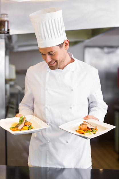 Smiling male chef with cooked food in kitchen