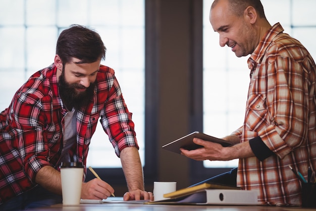 Smiling male colleagues discussing in creative office