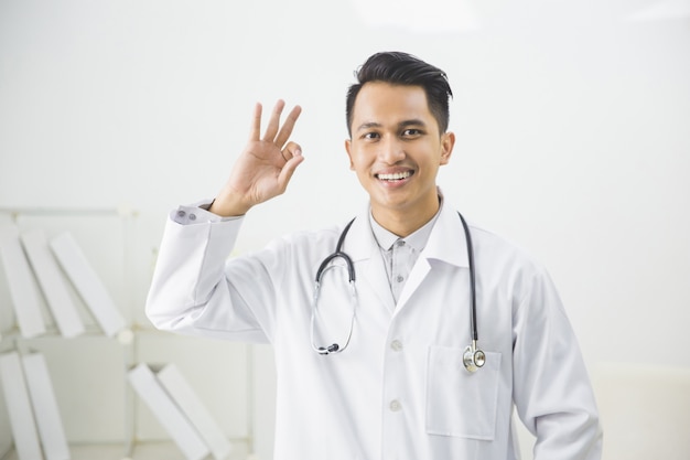 Smiling male doctor gesturing okay