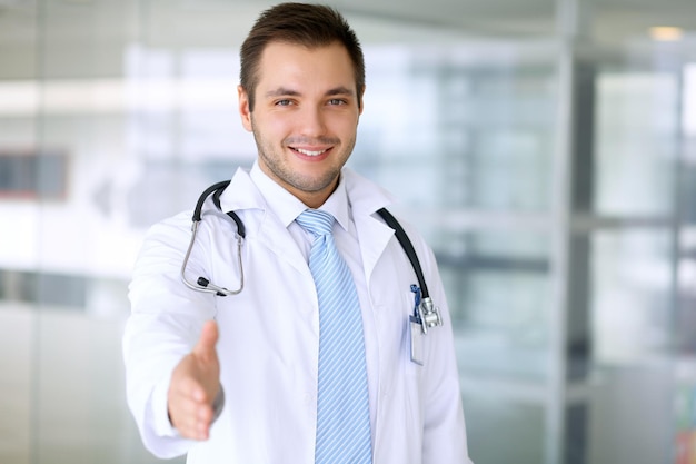 Smiling male doctor is ready for handshake