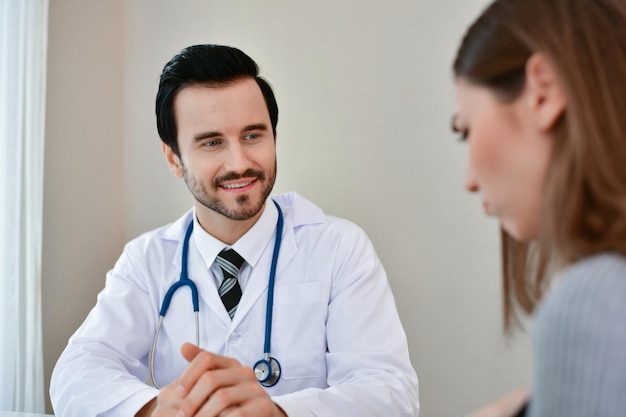 smiling male doctor looking at woman in hospital